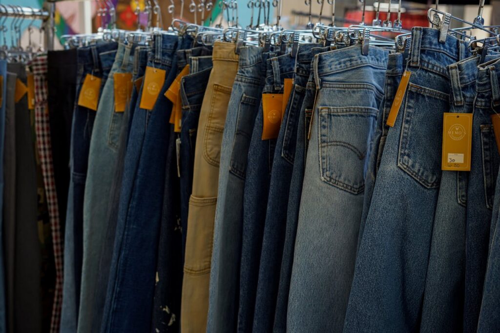 A variety of denim jeans displayed on hangers in a clothing store, highlighting fabric texture.